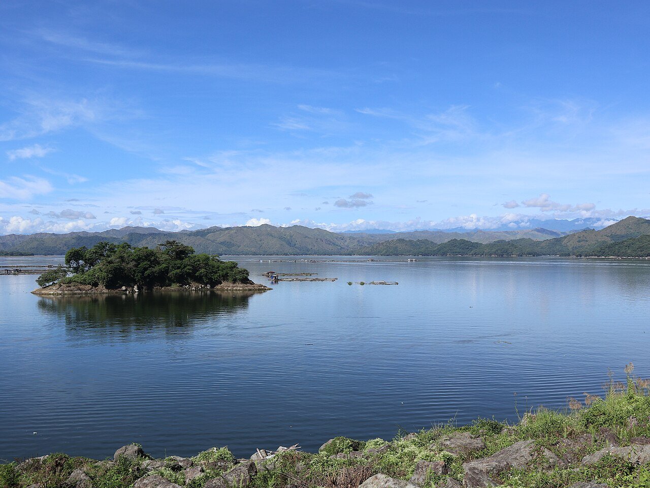 Magat Dam reservoir in Ramon, Isabela, with an island and mountains under a blue sky